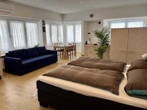 a bedroom with a large bed and a blue couch at Gästehaus Rheinstetten Forchheim in Rheinstetten