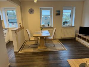 - une salle à manger avec une table et des chaises en bois dans l'établissement Ferienwohnung Nebelhorn in Dagebüll, à Dagebüll