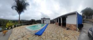 uma casa com piscina ao lado de um edifício em Chácara Recanto da Paz em Igaratá
