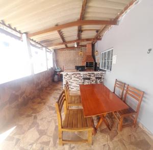 uma sala de jantar com uma mesa de madeira e cadeiras em Chácara Recanto da Paz em Igaratá