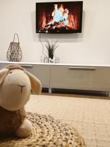 un animal de peluche sentado en un sofá frente a una TV en Ferienwohnung Samy, en Bayreuth