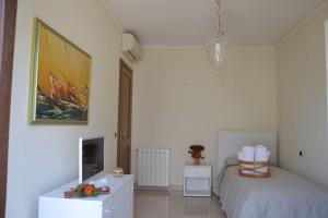 a bedroom with a bed and a dresser and a table at Appartamento centrale elegante in Olbia