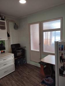 a kitchen with a refrigerator and a window in it at One room in apartment in the park center area of Chisinau in Chişinău