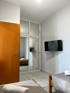 a bedroom with a sliding glass door and a tv at The Sunlit Retreat in Kremasti