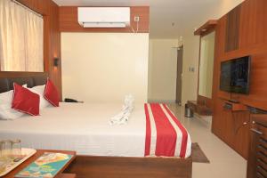 een hotelkamer met een bed en een televisie bij Hotel Mayuri in Digha