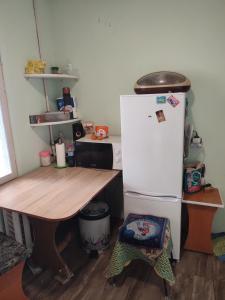 a kitchen with a wooden table and a refrigerator at One room in apartment in the park center area of Chisinau in Chişinău
