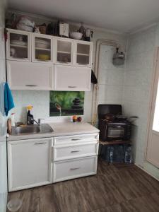 a kitchen with white cabinets and a sink at One room in apartment in the park center area of Chisinau in Chişinău