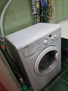 a washing machine sitting in a kitchen with its door open at One room in apartment in the park center area of Chisinau in Chişinău