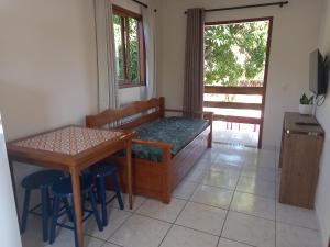 Cette chambre comprend un lit, une table et des chaises. dans l'établissement Recanto da Lagoa, à Florianópolis