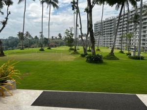 un parc verdoyant avec des palmiers et un grand bâtiment dans l'établissement Canterbury Residence Garden Apartments, à Kahatuduwa