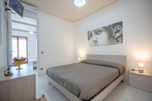 1 dormitorio con 1 cama y una pintura en la pared en Il Corallo, en Vasto