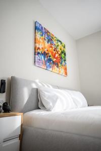 a painting hanging on a wall above a bed at O&O Group - Amazing Seaview 3 BR Apartment in Bat Yam