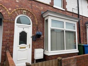 a white door and a window on a brick house at Central Blue Holiday Home. in Bridlington
