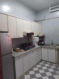 una cucina con armadietti bianchi e frigorifero bianco di EMPRESS SIGNATURE a Kuala Lumpur