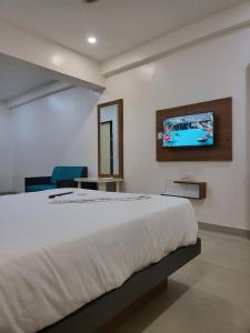 a bedroom with a bed and a tv on the wall at Hotel Stay Prime in Pune