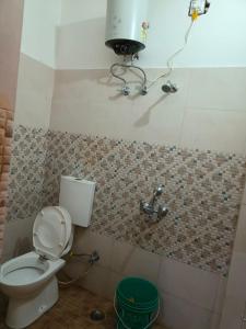 y baño con aseo y ducha. en Paradise Inn, en Jasidih