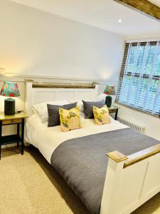 een slaapkamer met een groot wit bed met kussens bij Nine Cooper Lane, Holmfirth in Holmfirth