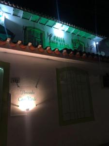 a sign on the side of a building at night at Pousada Coco Verde in Paraty