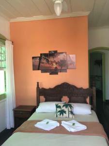 a bedroom with a bed with two towels on it at Pousada Coco Verde in Paraty