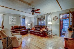 sala de estar con muebles de cuero y ventilador de techo en White Laurel Cottage At Linville Falls, en Linville Falls