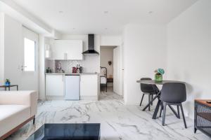 a white living room with a table and a couch at Spacious flat for 4 people #1 in Asnières-sur-Seine +1 photo