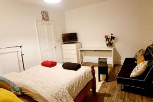 1 dormitorio con cama, escritorio y sofá en Cosy split-level 2 bed apartment en Leicester