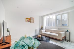 a living room with a couch and a tv at Spacious flat for 4 people #1 in Asnières-sur-Seine