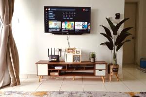 TV colgada en la pared de la sala de estar en Santai at KotaWarisan KLIA Netflix en Sepang