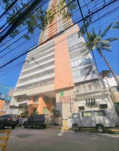 マニラにあるBirch Tower Malate Suitesの車が目の前に停まった高い建物
