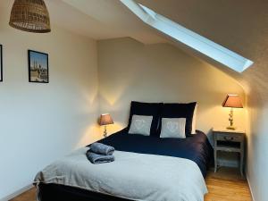 a bed in a room with two lamps and a bed sidx sidx sidx at Le 6 appartement Caen Port & Abbaye-aux-Dames in Caen