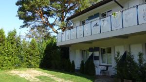a white house with a balcony on the side of it at ALOHA Rowy in Rowy