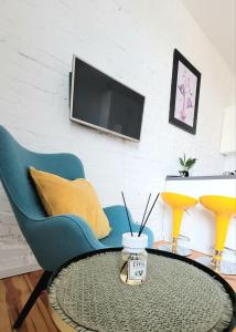 - un salon avec une table, des chaises et une télévision dans l'établissement apartament w centrum miasta, à Bydgoszcz