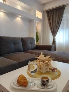 - un salon avec un canapé et une table avec du café et des biscuits dans l'établissement PERLA PREMIUM APARTMENT, à Timişoara