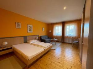 a bedroom with a bed and a couch and a chair at Landgasthof Zum Alten Weinstock in Rudersdorf