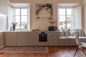 kuchnia z białymi szafkami i kanapą z oknami w obiekcie OGNISSANTI Nest-Hosted by Sweetstay we Florencji