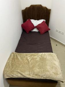 a bed with two pillows on top of it at 30 R4 Single 1 Small Room in 3-bedroom apartment with attached washroom with fantastic sea view 30 R4 غرفة مفردة واحدة صغيرة في شقة مكونة من 3 غرف نوم مع حمام ملحق وإطلالة رائعة على البحر in Ajman 