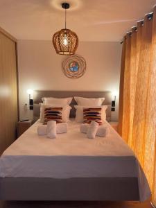 - une chambre dotée d'un grand lit avec des draps et des oreillers blancs dans l'établissement Bergerie vue mer avec piscine, à Ventiseri
