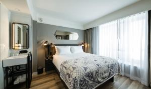 a bedroom with a bed and a sink and a window at Pestana Park Avenue in New York