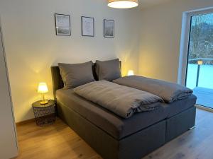 Cama en habitación con lámpara en el suelo en Haus Sonnenwinkl, en Kössen