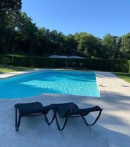 a pair of glasses sitting next to a swimming pool at Chateau Pont Jarno B&B in Champdeniers-Saint-Denis