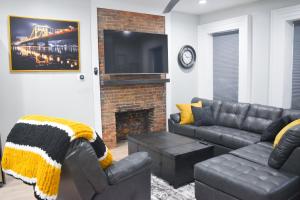 sala de estar con sofá y chimenea en Steel City Getaway w/City View, en Pittsburgh
