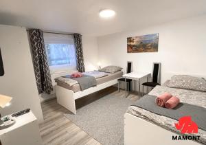 1 dormitorio con 2 camas y escritorio. en Gemütliche Monteurwohnung im Souterrain, en Bremen