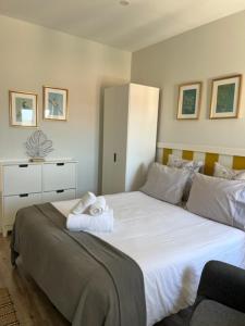 sypialnia z dużym białym łóżkiem z ręcznikami w obiekcie Lovely Monsanto View Studio Apartment in Campolide - 47 2D w Lizbonie
