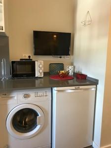a kitchen with a washing machine and a microwave at Lovely Monsanto View Studio Apartment in Campolide - 47 2D in Lisbon