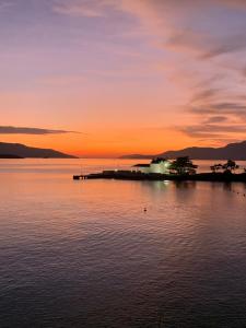 an island in the water at sunset at Apartamento Praia do Bonfim in Angra dos Reis +12 photos