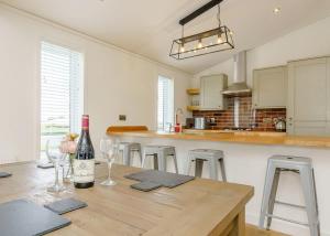 a kitchen with a wooden table with a bottle of wine at Winston Farm Lodges 