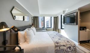 a hotel room with a bed and a flat screen tv at Pestana Park Avenue in New York