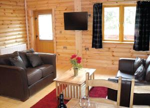 a living room with a couch and a table at Beech Hedge in Coupar Angus