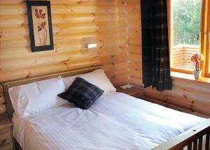 um quarto com uma cama num chalé de madeira em Beech Hedge em Coupar Angus