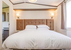 a bedroom with a large white bed with two pillows at Looe Coastal Retreat in Looe